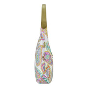 Side view of a white paisley-patterned Anuschka sling bag with green shoulder strap and zippered pockets.