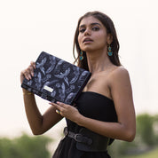 Woman posing with an Anuschka fabric with leather trim toiletry case featuring zippered pockets.