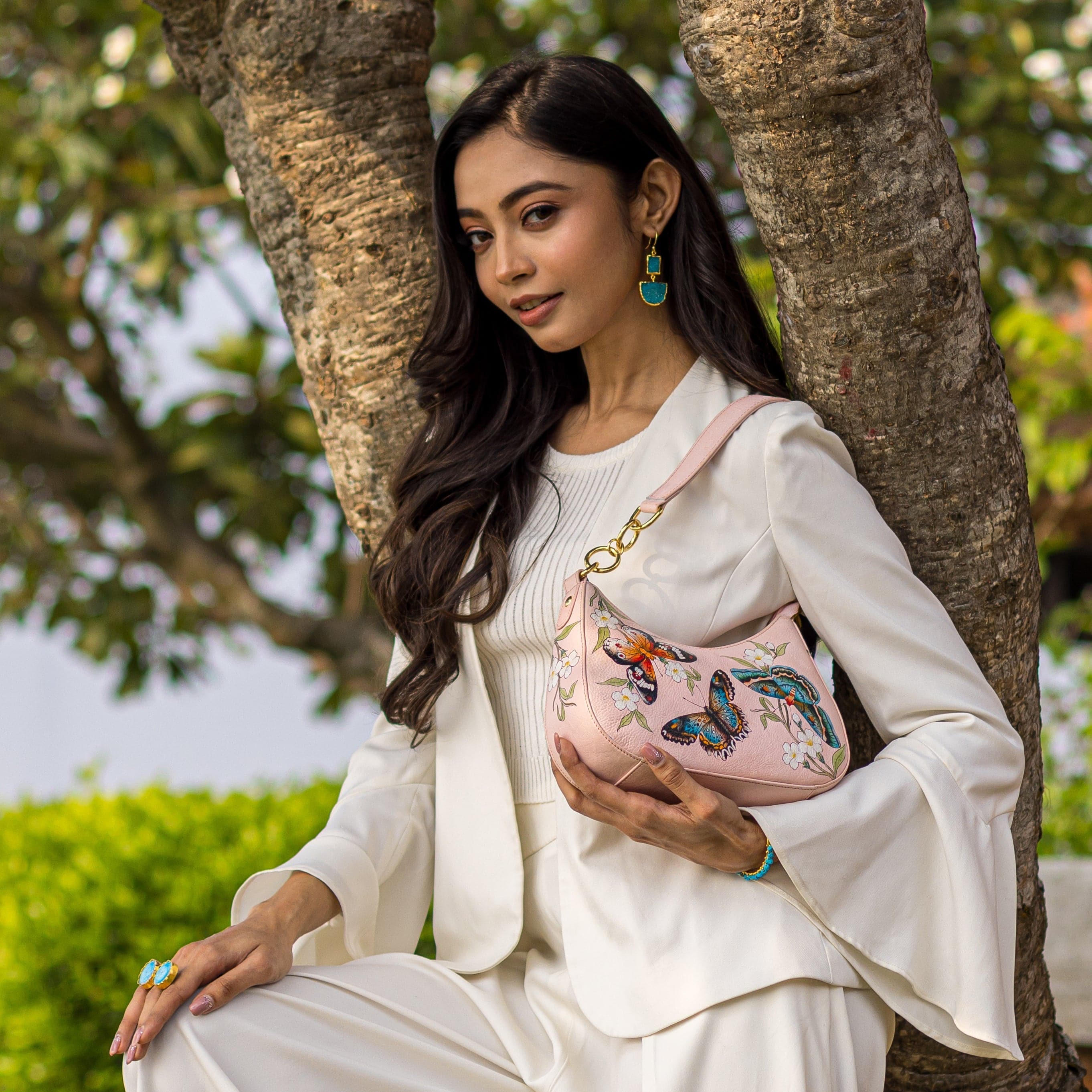 Woman posing outdoors with an Anuschka Small Convertible Hobo - 701 genuine leather shoulder bag.