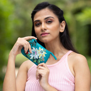 Woman holding a Anuschka genuine leather floral zip pouch (1107) outdoors.