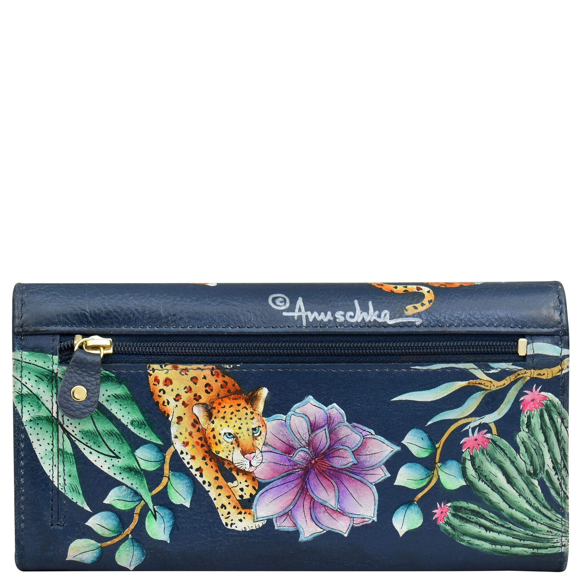 This accordion flap wallet (model 1112) by Anuschka is crafted from genuine navy blue leather and features a stunning hand-painted design with leopards, cacti, and pink flowers. It includes a zipper with a black leather pull tab and gold snap button. The "Anuschka" branding is clearly visible, and it also offers RFID protection for added security.