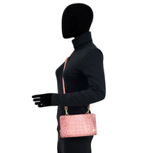 Load image into Gallery viewer, Mannequin with a black bodysuit and gloves holding an Anuschka Organizer Wallet Crossbody - 1149 with RFID protection against a white background.
