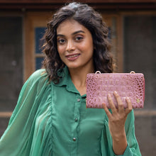 Load image into Gallery viewer, A woman with wavy hair holding an Anuschka Organizer Wallet Crossbody - 1149 with RFID protection.
