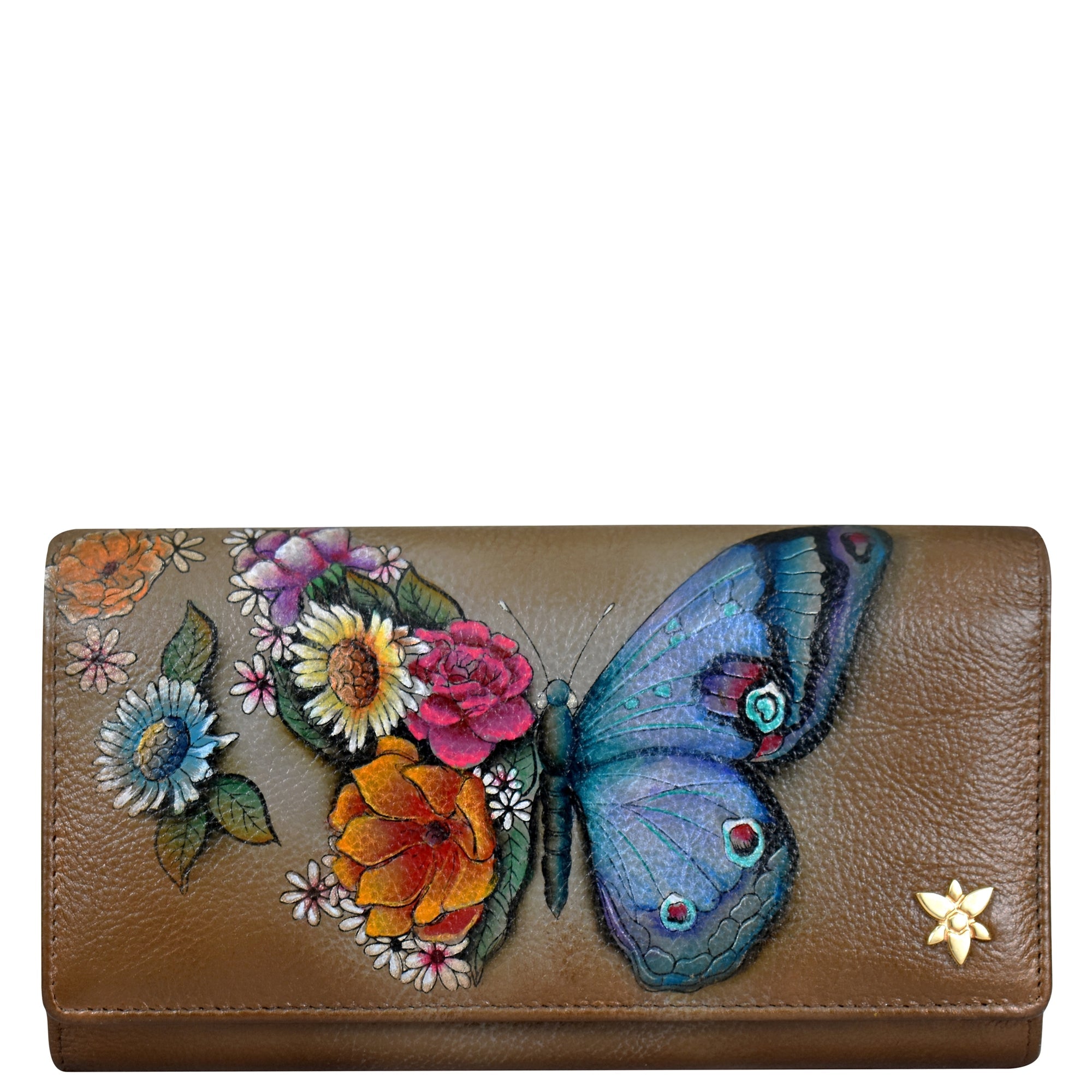 The Anuschka Triple Fold RFID Clutch Wallet - 1150 showcases hand-painted artwork of a blue butterfly among various colorful flowers, adorned with a small golden floral ornament in the bottom right corner. This genuine leather wallet combines exquisite beauty with practical functionality, including RFID protection.