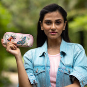 Woman holding a hand-painted, decorated Medium Zip-Around Eyeglass/Cosmetic Pouch - 1163 by Anuschka outdoors.