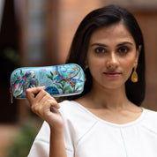 A woman holding a hand-painted, turtle-themed Anuschka Medium Zip-Around Eyeglass/Cosmetic Pouch - 1163.