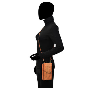 A side profile of a mannequin wearing a black turtleneck and pants with a small Anuschka Crossbody Phone Case - 1173 for a wallet.