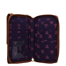 Load image into Gallery viewer, Open empty Anuschka crossbody phone case with a floral pattern interior and pockets.

