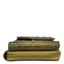 Load image into Gallery viewer, A stack of two closed, vintage leather-bound books with an Anuschka Crossbody Phone Case - 1173 at the bottom, isolated on a white background.
