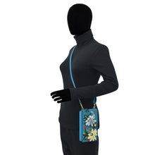 Load image into Gallery viewer, Mannequin wearing a black balaclava, grey jacket, and gloves holding a floral-patterned blue Anuschka Crossbody Phone Case - 1173 with an RFID card holder.
