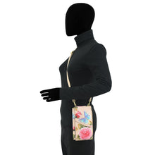 Load image into Gallery viewer, Mannequin wearing a black bodysuit and showcasing a floral Anuschka RFID crossbody phone case - 1173.
