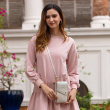 Load image into Gallery viewer, A woman in a pink dress standing outdoors with an Anuschka genuine leather crossbody phone case - 1173.
