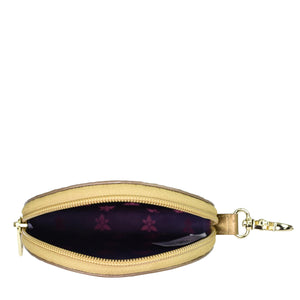 A small, round, yellow zippered Anuschka Round Coin Purse - 1175 with a floral-patterned interior and a metal clasp.