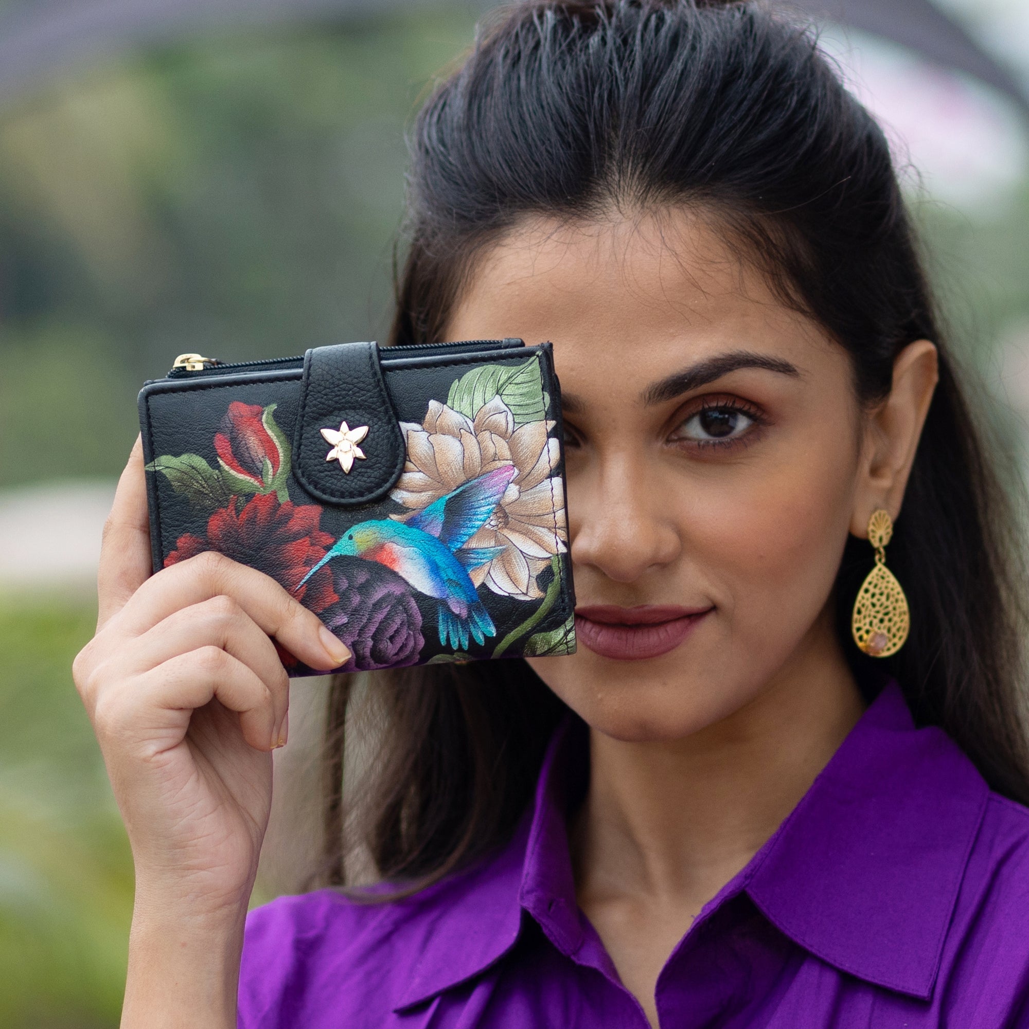 Woman showcasing a floral Anuschka Two Fold Organizer Wallet - 1178.