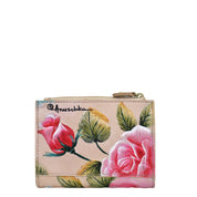 A beige Two Fold Organizer Wallet - 1178 crafted from genuine leather with hand-painted pink roses and green leaves, featuring a zipper on top. Perfect for minimalists, this compact wallet from Anuschka combines elegance with simplicity.