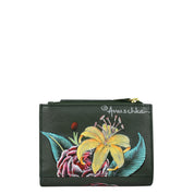 Anuschka's Two Fold Organizer Wallet - 1178 is a stylish and functional compact wallet made from green genuine leather. It features a hand-painted floral design with yellow lilies and red flowers, along with the visible 'Anuschka' signature.