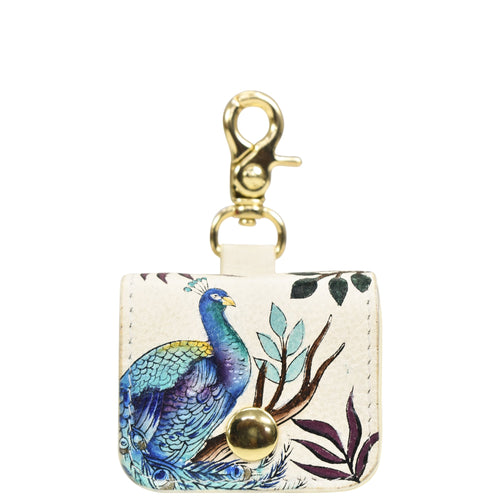 Decorative keychain featuring a peacock design on a white, genuine leather Anuschka Airpod Pro Case - 1179 with a gold-tone clasp.