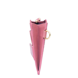 Side view of a closed pink umbrella with a golden handle, featuring an integrated Anuschka RFID Card Holder with Wristlet - 1180 for enhanced organization.