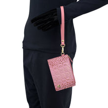 Load image into Gallery viewer, Person wearing black with gloves holding a pink textured Anuschka RFID Card Holder with Wristlet - 1180.
