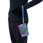 Person in black long-sleeve shirt and pants holding an Anuschka Card Holder with Wristlet - 1180 with a blue strap.