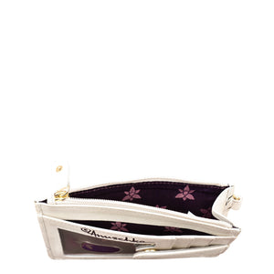 Open white Anuschka genuine leather clutch purse with floral interior design displayed on a white background.