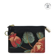 Introducing the CARD CASE - 1183 from Anuschka, a charming small leather coin purse adorned with an exquisite floral design showcasing red roses and green leaves. It features a convenient zipper closure and a sturdy metal keyring attachment. The top right corner is stamped with "Sustainable Tanned Genuine Leather," underscoring its commitment to sustainability. This genuine leather accessory is perfect for those who value both style and eco-conscious products.