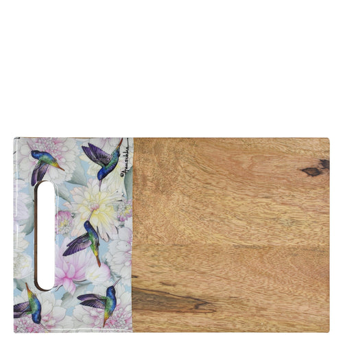 A Anuschka mango wood cutting board with one half covered in a floral and butterfly design.