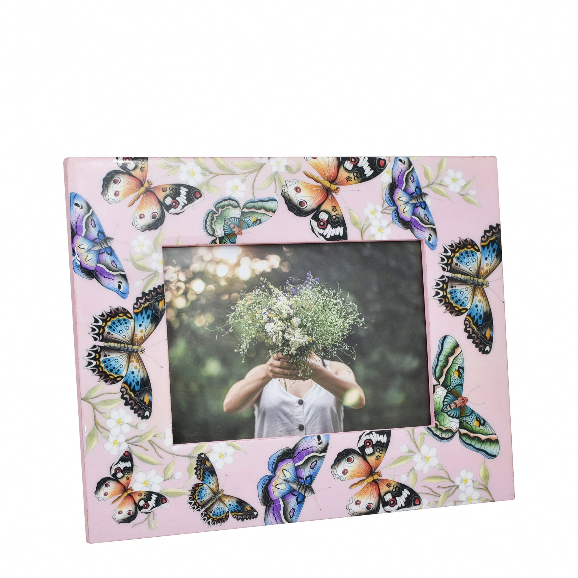 Decorative pink Anuschka printed photo frame adorned with butterfly motifs surrounding a picture of a person holding a bouquet of flowers in front of their face.