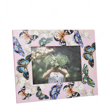 Load image into Gallery viewer, Decorative pink Anuschka printed photo frame adorned with butterfly motifs surrounding a picture of a person holding a bouquet of flowers in front of their face.
