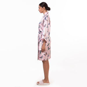 A woman standing in profile wearing an Anuschka floral 3343 robe, embodying self-care and relaxation.