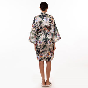 A person standing with their back toward the camera, wearing a silky, floral Anuschka kimono-style robe - 3343.