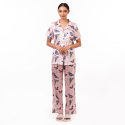 Woman standing in a pink printed Anuschka Pajama Set - 3344 made from recycled fabric against a white background.