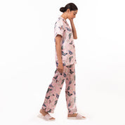 A woman wearing an Anuschka pajama set-3344 made from recycled fabric, standing in a side profile view against a white background.