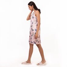 Load image into Gallery viewer, A woman in a floral slip dress made of recycled polyester by Anuschka, style 3346, walking against a white background, featuring adjustable shoulder straps.
