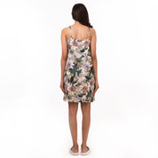 Woman standing with her back to the camera, wearing a chic floral slip dress by Anuschka - 3346.