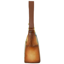 Load image into Gallery viewer, Side view of the Anuschka Classic Hobo With Side Pockets - 382, a brown genuine leather handbag with a thick shoulder strap and hand-painted floral patterns on the sides.
