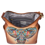 The Anuschka Classic Hobo With Side Pockets - 382 is a genuine leather handbag featuring vibrant, hand-painted elephant artwork on the front. When unzipped, it reveals a floral-patterned interior along with an inner zip pocket for added convenience.