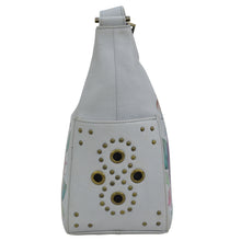 Load image into Gallery viewer, White Anuschka Classic Hobo With Studded Side Pockets - 433 backpack with metal grommet embellishments on a plain background.

