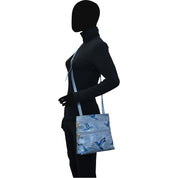 Person with a silhouette face wearing a black leather outfit and carrying an Anuschka Medium Crossbody With Double Zip Pockets - 447 with an adjustable strap and zebra pattern.