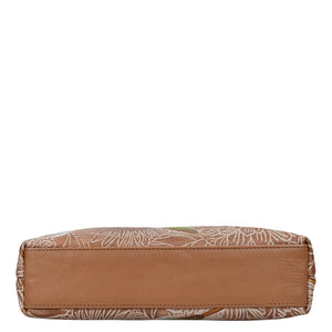 Brown and patterned rectangular zippered Anuschka genuine leather wallet isolated on a white background.