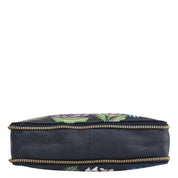 Circular cosmetic bag with floral pattern, zipper closure, and adjustable shoulder strap on a white background: Anuschka Expandable Travel Crossbody - 550