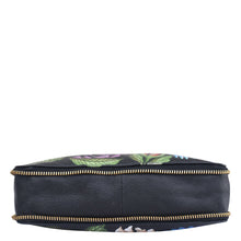 Load image into Gallery viewer, Circular cosmetic bag with floral pattern, zipper closure, and adjustable shoulder strap on a white background: Anuschka Expandable Travel Crossbody - 550
