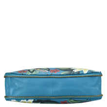 Load image into Gallery viewer, Anuschka Expandable Travel Crossbody - 550 genuine leather cosmetic bag with a floral patterned blue design, isolated on a white background.

