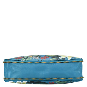 Anuschka Expandable Travel Crossbody - 550 genuine leather cosmetic bag with a floral patterned blue design, isolated on a white background.