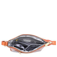 Load image into Gallery viewer, The Anuschka Expandable Travel Crossbody - 550 is a small, opened brown handbag made of genuine leather with a gold zipper, featuring multiple inner compartments and pockets lined with grey patterned fabric.
