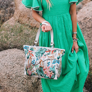 Woman in a green dress holding an Anuschka Classic Work Tote - 664 outdoors.