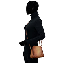 Load image into Gallery viewer, Mannequin wearing a black leather outfit with a shoulder bag featuring an adjustable strap by Anuschka.
