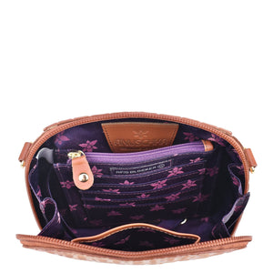 Open Anuschka hand-painted leather bag showcasing RFID protection and interior design, complete with an adjustable strap.