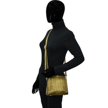 Load image into Gallery viewer, Mannequin dressed in black outfit with a gold zipper displaying a chic, Anuschka Zip Around Travel Organizer - 668.
