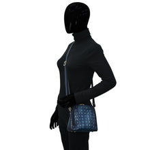 Load image into Gallery viewer, Person wearing a black full-body suit and gloves holding a blue Anuschka Zip Around Travel Organizer - 668 with RFID protection.
